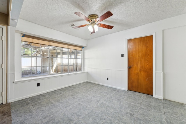 unfurnished room with a textured ceiling and ceiling fan