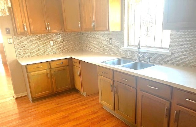 kitchen featuring sink, light hardwood / wood-style floors, and tasteful backsplash