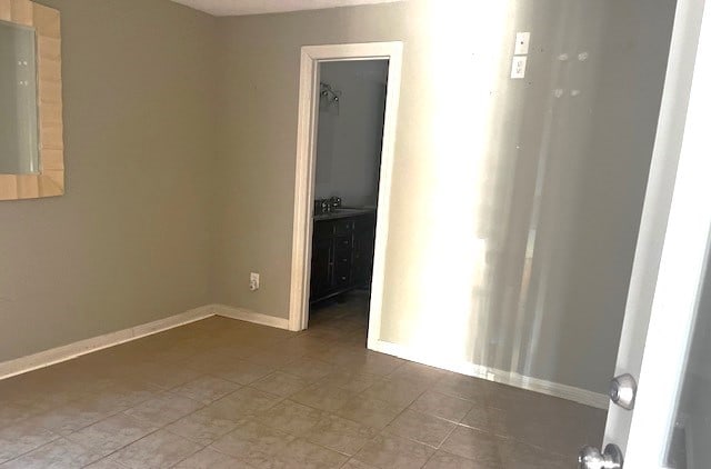 empty room with tile patterned flooring and sink