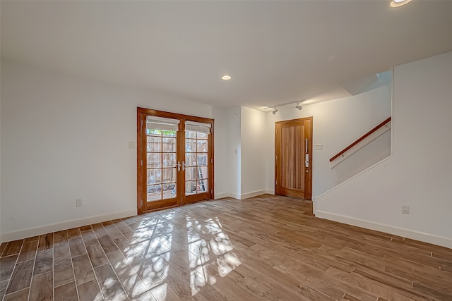 spare room with french doors and hardwood / wood-style flooring