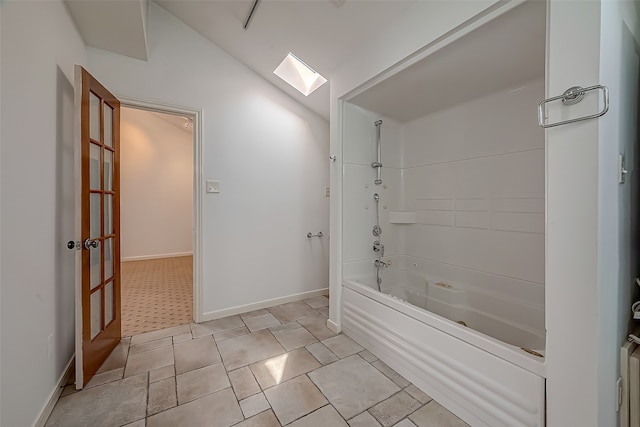 bathroom featuring lofted ceiling with skylight and shower / bath combination