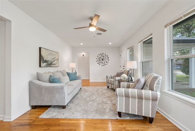 living room featuring ceiling fan, a wealth of natural light, and light hardwood / wood-style flooring