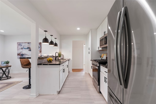 kitchen featuring sink, white cabinetry, hanging light fixtures, and stainless steel appliances