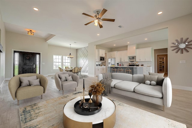 living room with ceiling fan and light hardwood / wood-style floors