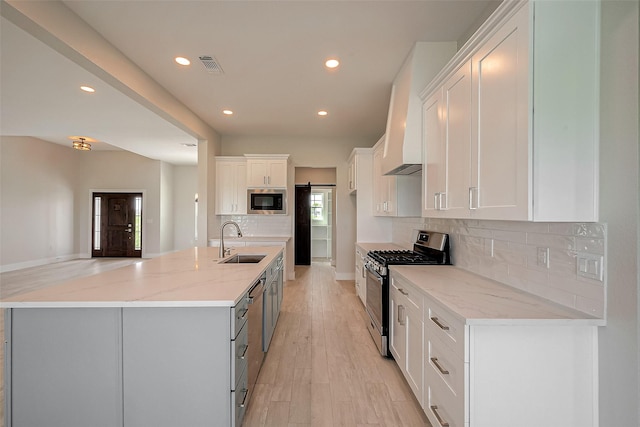 kitchen featuring white cabinets, light stone counters, sink, and stainless steel appliances