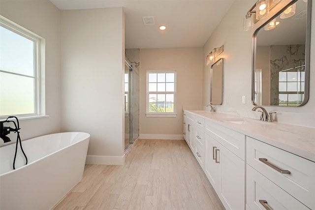 bathroom with hardwood / wood-style floors, vanity, and separate shower and tub