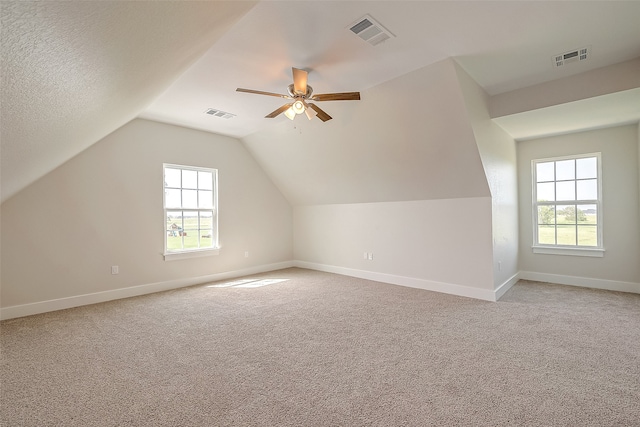 bonus room featuring a textured ceiling, ceiling fan, light carpet, and vaulted ceiling