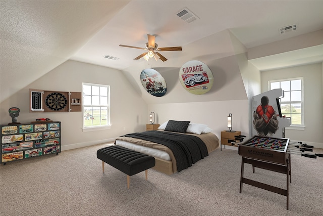 carpeted bedroom featuring ceiling fan, a textured ceiling, and vaulted ceiling