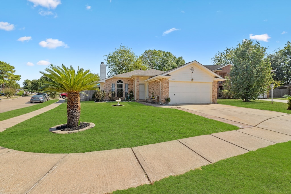 single story home featuring a front yard and a garage