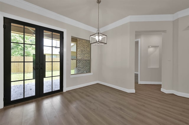 unfurnished dining area with french doors, a chandelier, wood-type flooring, and crown molding