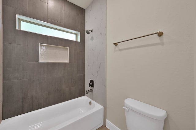 bathroom with toilet and tiled shower / bath combo