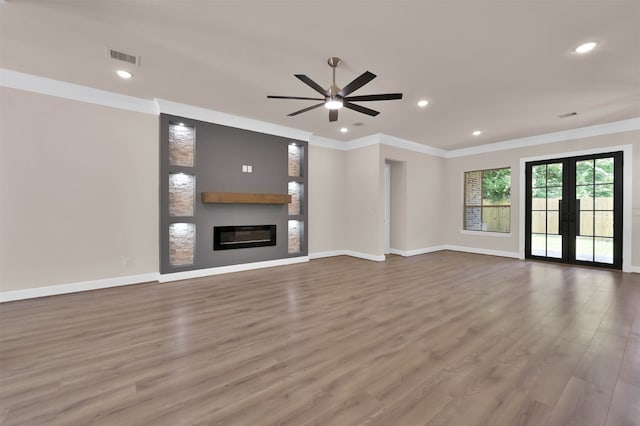 unfurnished living room with french doors, crown molding, wood-type flooring, and ceiling fan