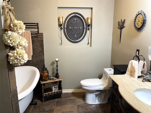 bathroom featuring vanity, toilet, and a washtub