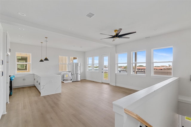 interior space with ceiling fan and light hardwood / wood-style floors