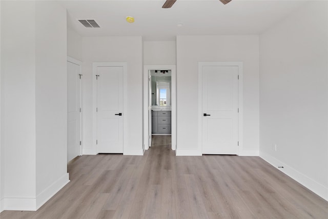 unfurnished bedroom with light wood-type flooring, ensuite bath, and ceiling fan