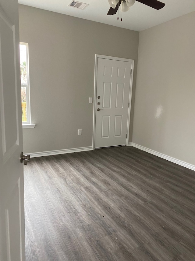 spare room featuring dark wood-type flooring and ceiling fan