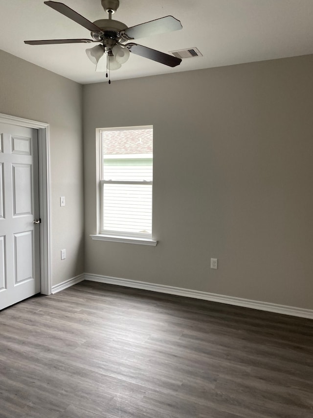 spare room with dark wood-type flooring and ceiling fan