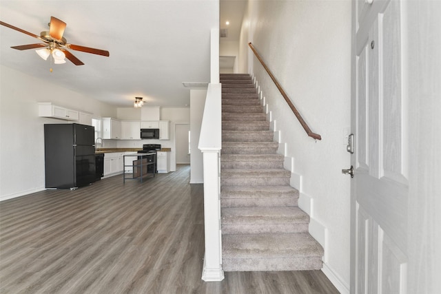 stairs with ceiling fan, sink, and wood-type flooring