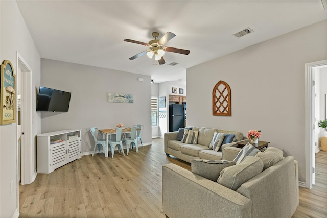 living room featuring ceiling fan and light hardwood / wood-style flooring