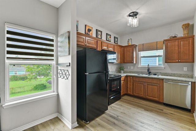 kitchen with black appliances, light hardwood / wood-style flooring, and sink