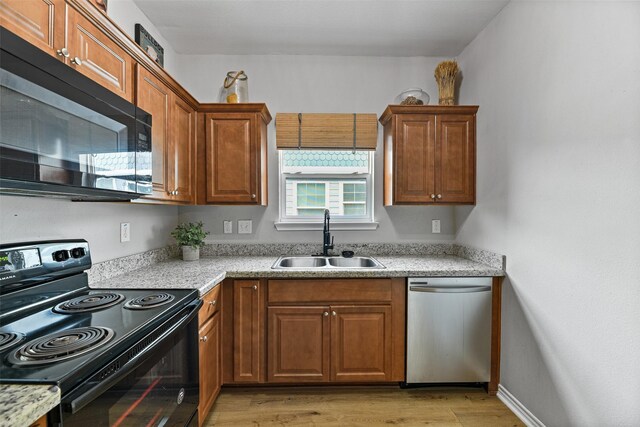 kitchen featuring sink, light hardwood / wood-style floors, and black appliances