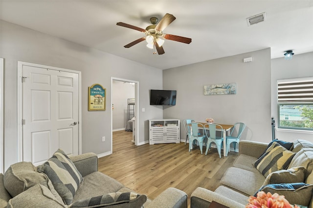 living room with ceiling fan and light hardwood / wood-style flooring