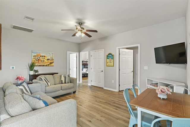 living room featuring ceiling fan and light hardwood / wood-style flooring