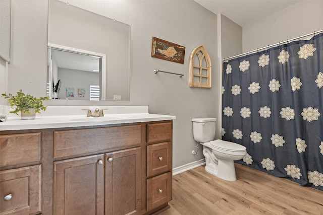 bathroom featuring toilet, vanity, and hardwood / wood-style floors