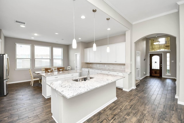 kitchen with white cabinetry, sink, plenty of natural light, pendant lighting, and a kitchen island with sink