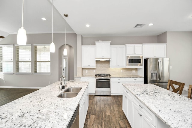 kitchen featuring white cabinetry, sink, hanging light fixtures, dark wood-type flooring, and stainless steel appliances