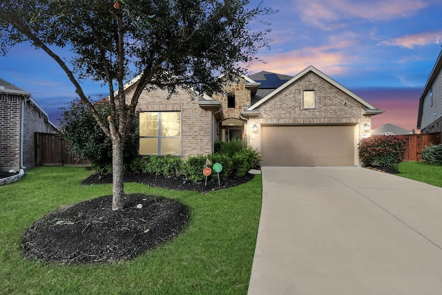 view of front of property with solar panels, a yard, and a garage