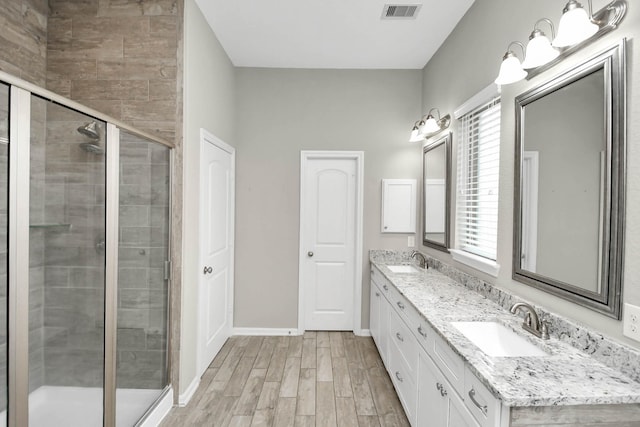 bathroom featuring a healthy amount of sunlight, vanity, wood-type flooring, and walk in shower