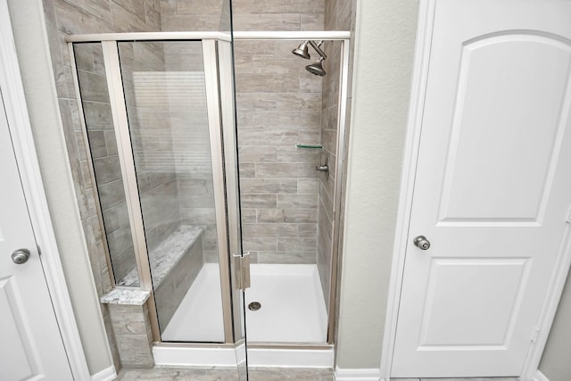 bathroom with a shower with door