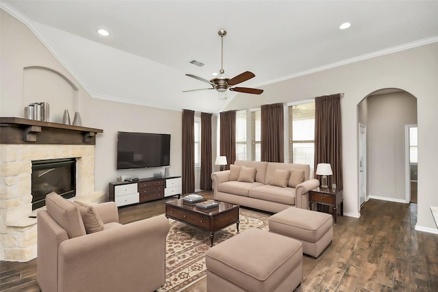 living room featuring ceiling fan, dark hardwood / wood-style flooring, crown molding, vaulted ceiling, and a fireplace