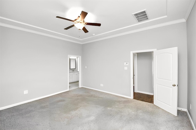 spare room featuring ceiling fan, dark carpet, and crown molding