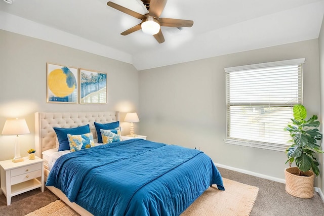 bedroom with ceiling fan, vaulted ceiling, and dark colored carpet