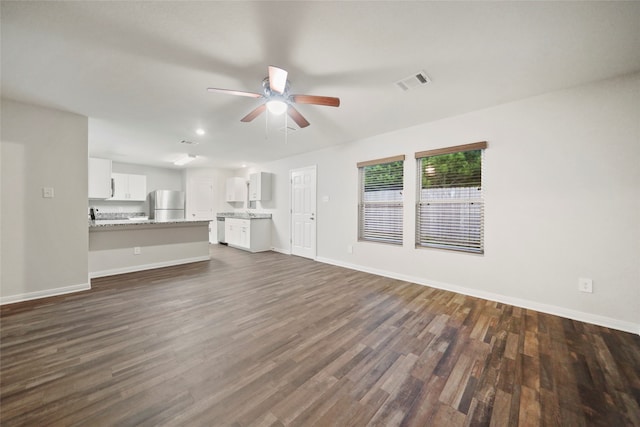 unfurnished living room with dark wood-type flooring and ceiling fan