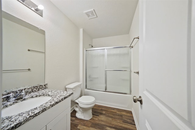 full bathroom with vanity, enclosed tub / shower combo, wood-type flooring, and toilet