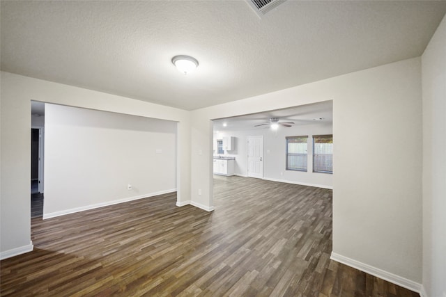 unfurnished living room featuring a textured ceiling, dark wood-type flooring, and ceiling fan