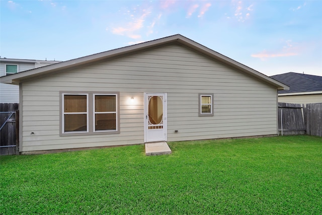 back of house with a lawn