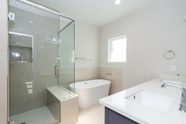 bathroom with vanity, tile walls, tile patterned floors, and plus walk in shower