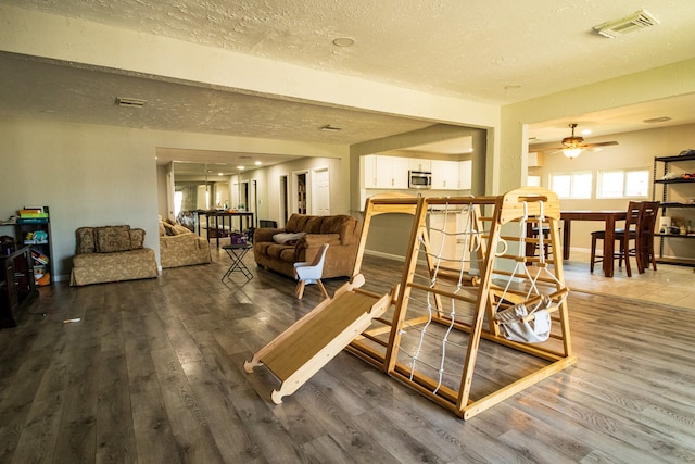 dining area with a textured ceiling, hardwood / wood-style flooring, and ceiling fan