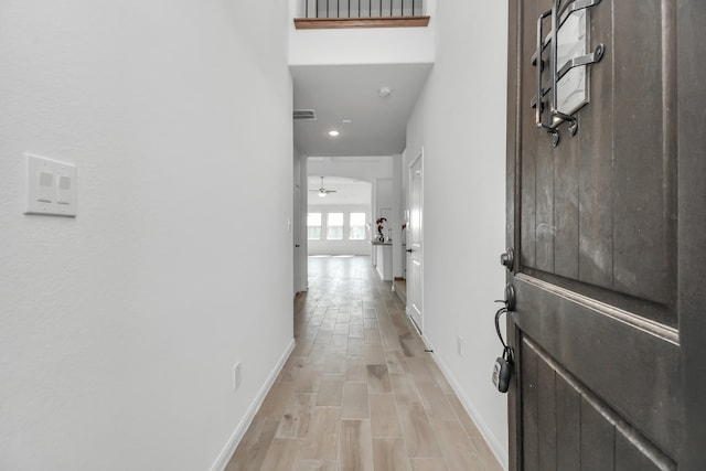 hallway with light hardwood / wood-style floors