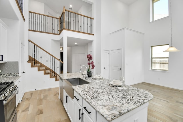 kitchen with a towering ceiling, gas range, and a wealth of natural light