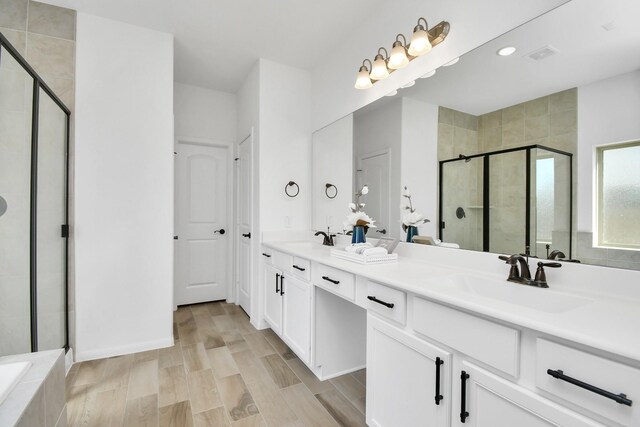 bathroom featuring vanity, hardwood / wood-style floors, and plus walk in shower