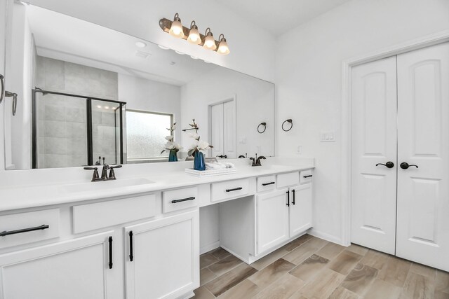 bathroom with vanity, hardwood / wood-style flooring, and a shower with door