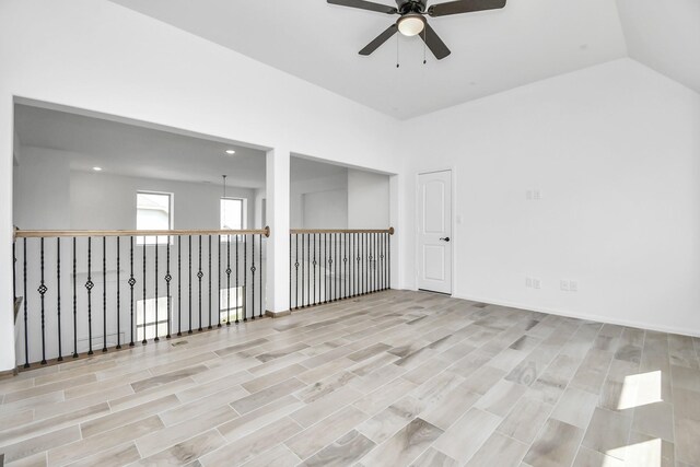 spare room with ceiling fan, lofted ceiling, and light hardwood / wood-style flooring