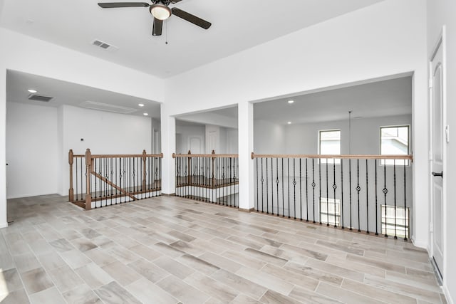 empty room with ceiling fan and light wood-type flooring