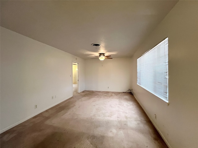 unfurnished room with light colored carpet and ceiling fan