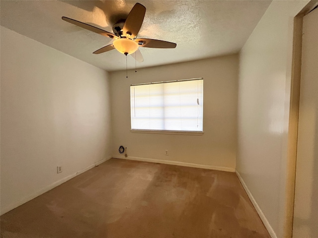 carpeted spare room featuring a textured ceiling and ceiling fan